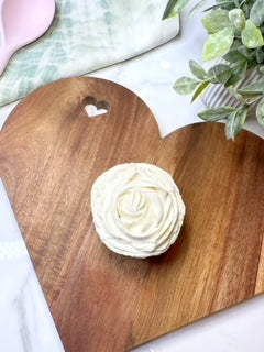 A stunning cupcake with white frosting piped in the style of a rose. 