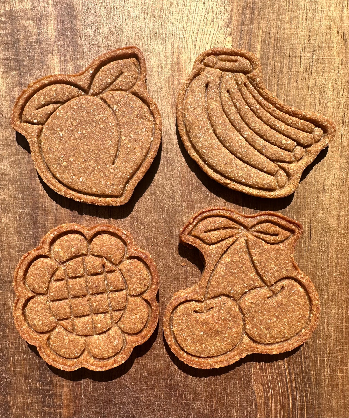 Four cute summer themed shapes can be seen. The shapes seen are a peach, sunflower, banana, and cherry.