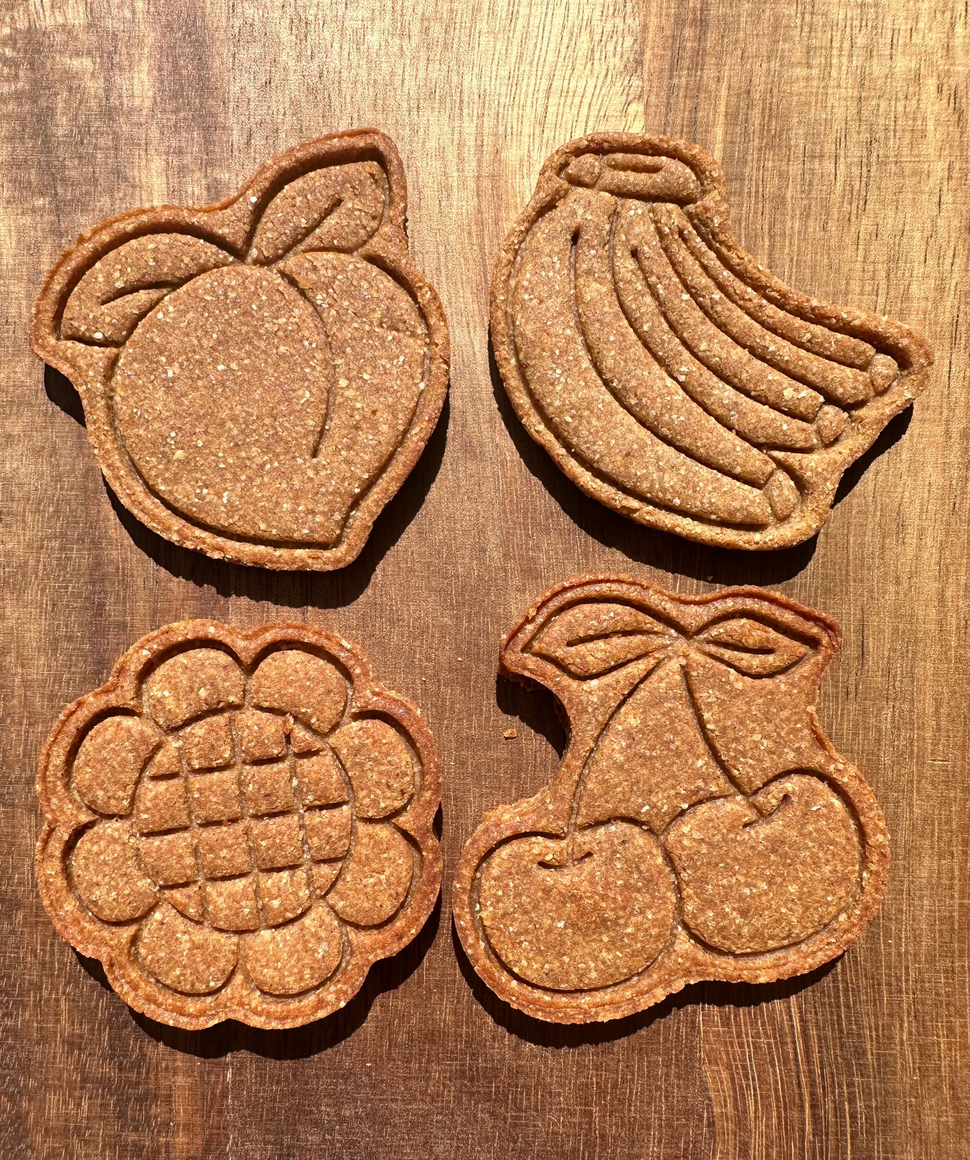 Four cute summer themed shapes can be seen. The shapes seen are a peach, sunflower, banana, and cherry.