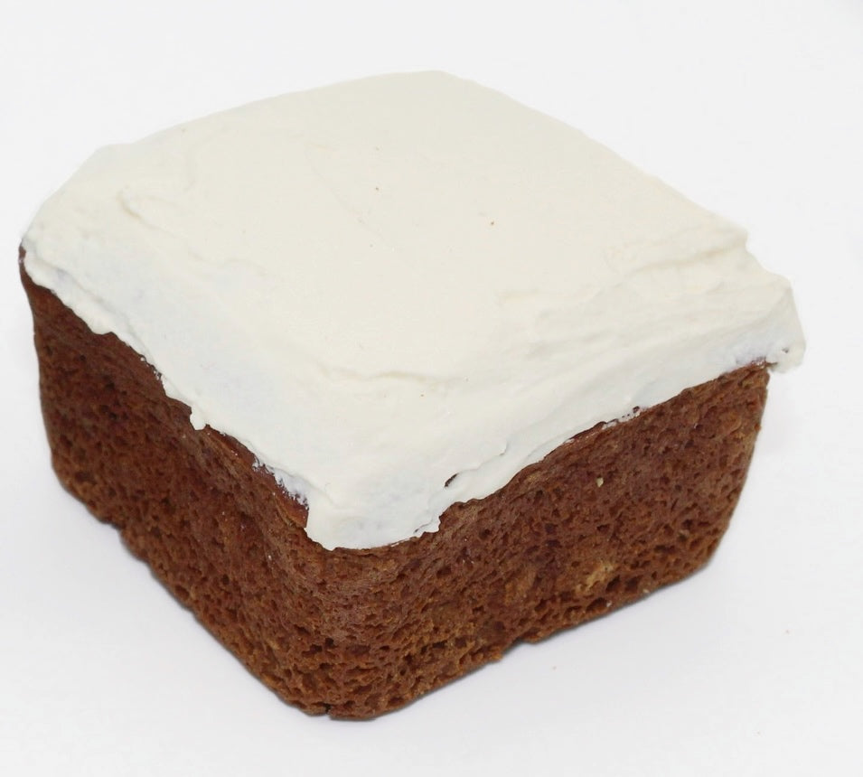 A delicious sweet potato and carrot mini dog cake with white dog safe frosting on top.