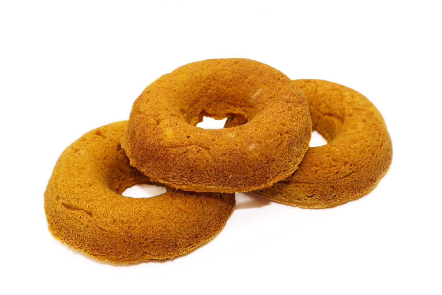 Three unfrosted plain pumpkin dog donuts.