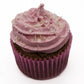 A berry looking cupcake wrapped in a pink paper liner, frosted with pink pipping and white coconut flakes.