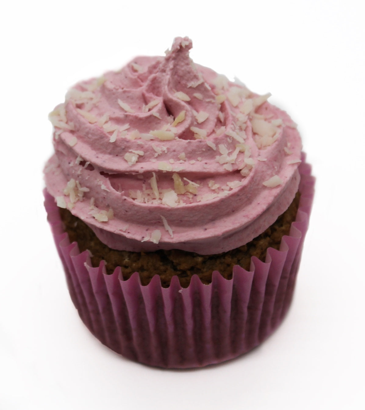 A berry looking cupcake wrapped in a pink paper liner, frosted with pink pipping and white coconut flakes.