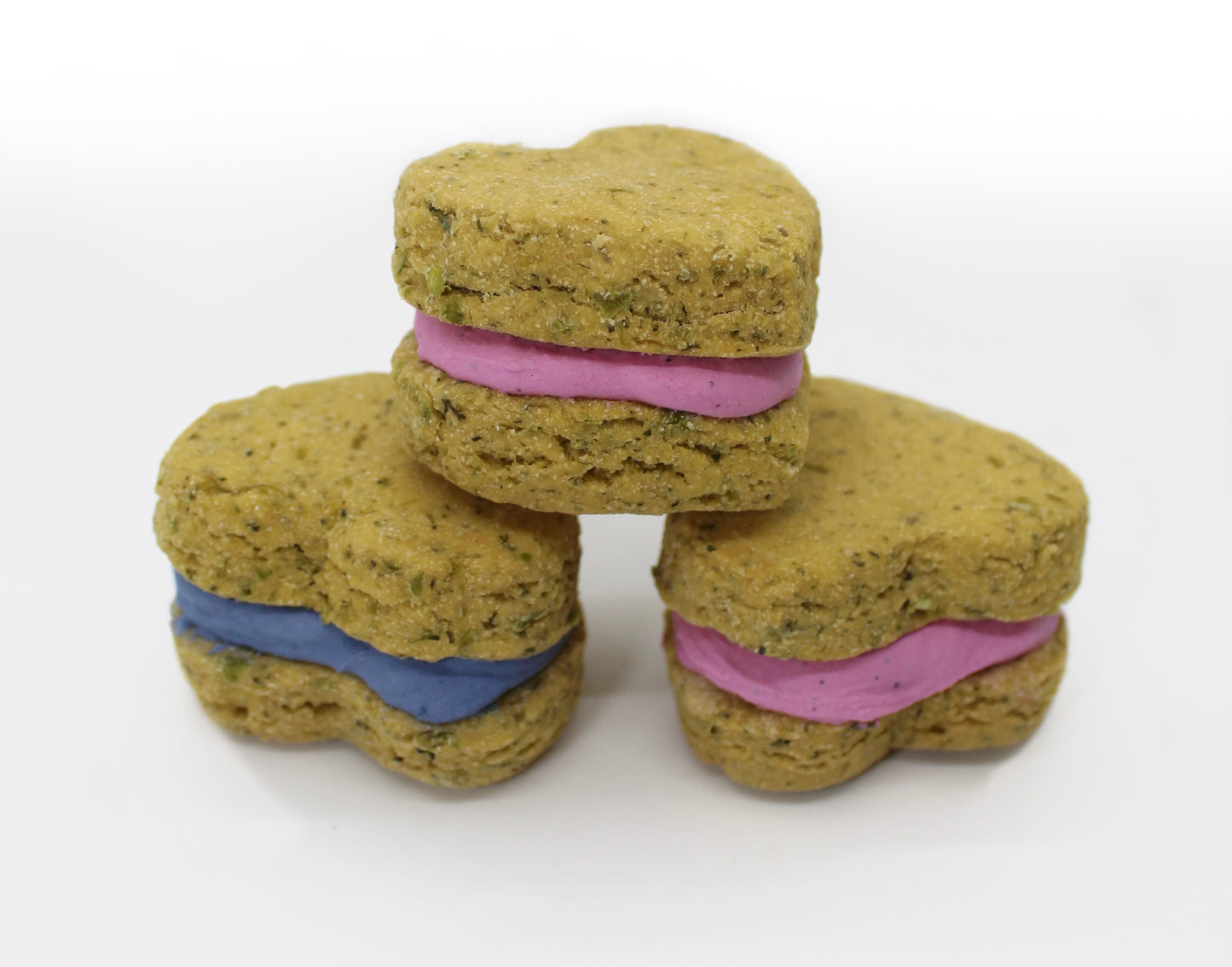 Three green whoopie heart dog treats stacked in a pyramid formation.