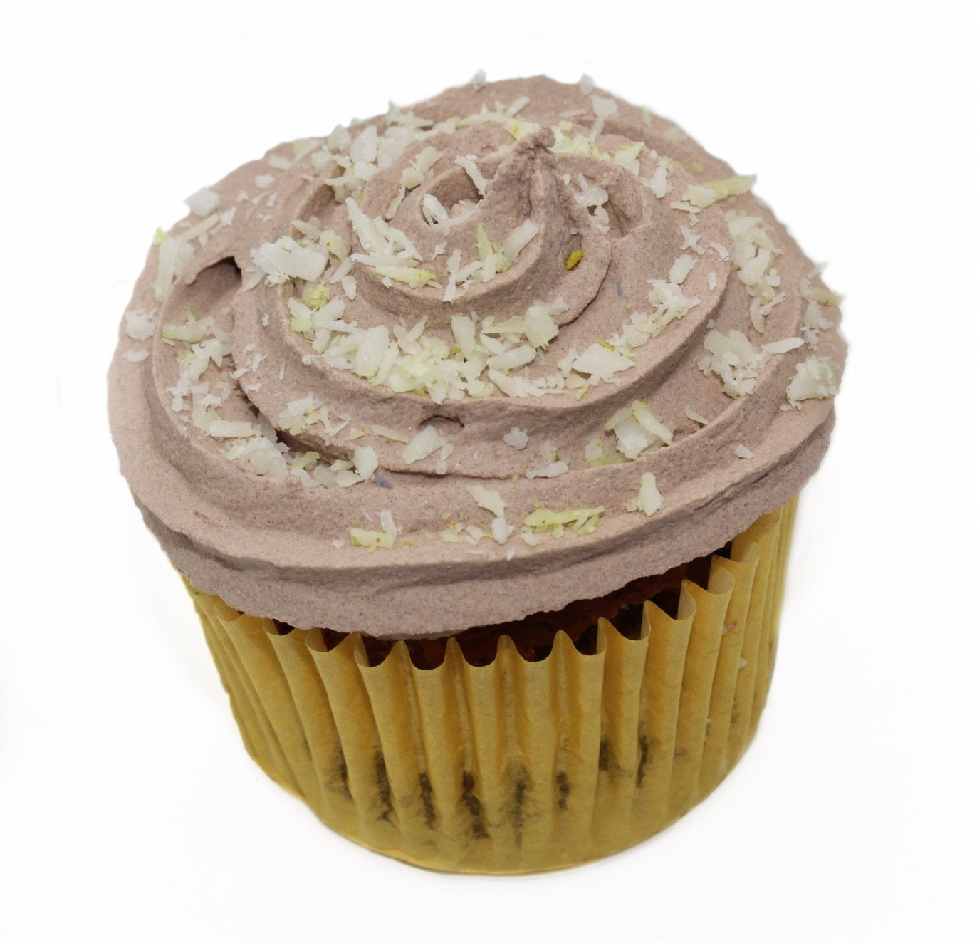 A tasty brown, carob frosted cupcake wrapped in a yellow paper liner with white and yellow coconut flakes sprinkled on top.