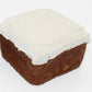 A delicious sweet potato and carrot mini dog cake with white dog safe frosting on top.